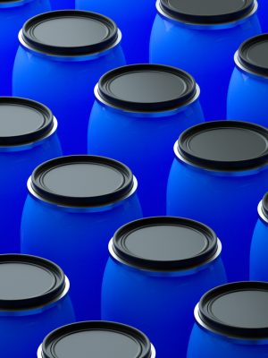 A clean, modern 3D render of numerous blue industrial barrels arranged in a neat, repeating pattern. This image is an excellent visual metaphor for mass production, industrial storage, supply chain logistics, and the chemical industry. The uniform arrangement creates a strong graphic background suitable for corporate presentations, industry reports, and websites related to manufacturing and large-scale distribution.