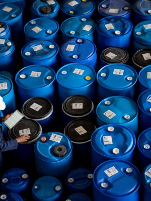 African American worker at a chemical plant doing an inventory of barrels of chemicals using a tablet computer - manufacturing industry concepts
